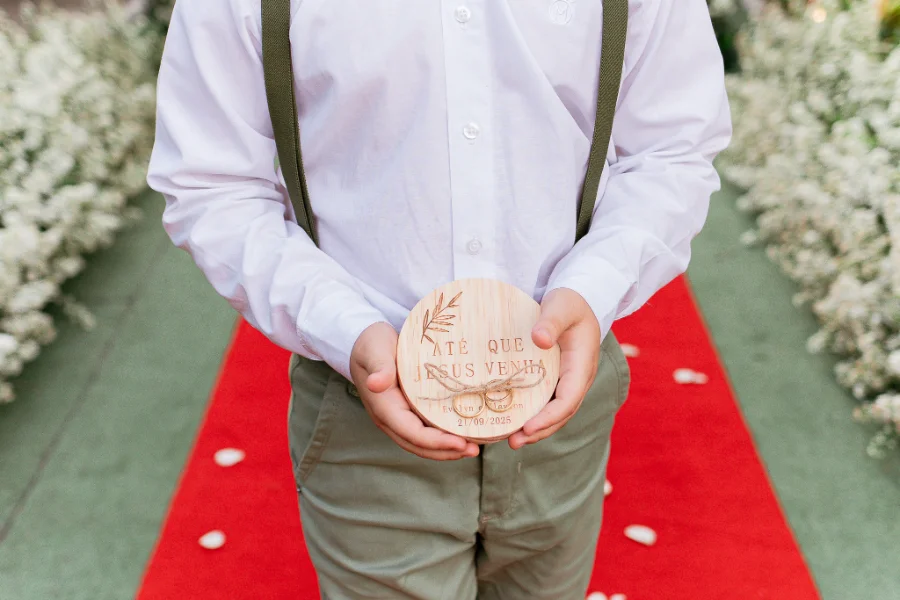 pajem levando porta alianças de madeira