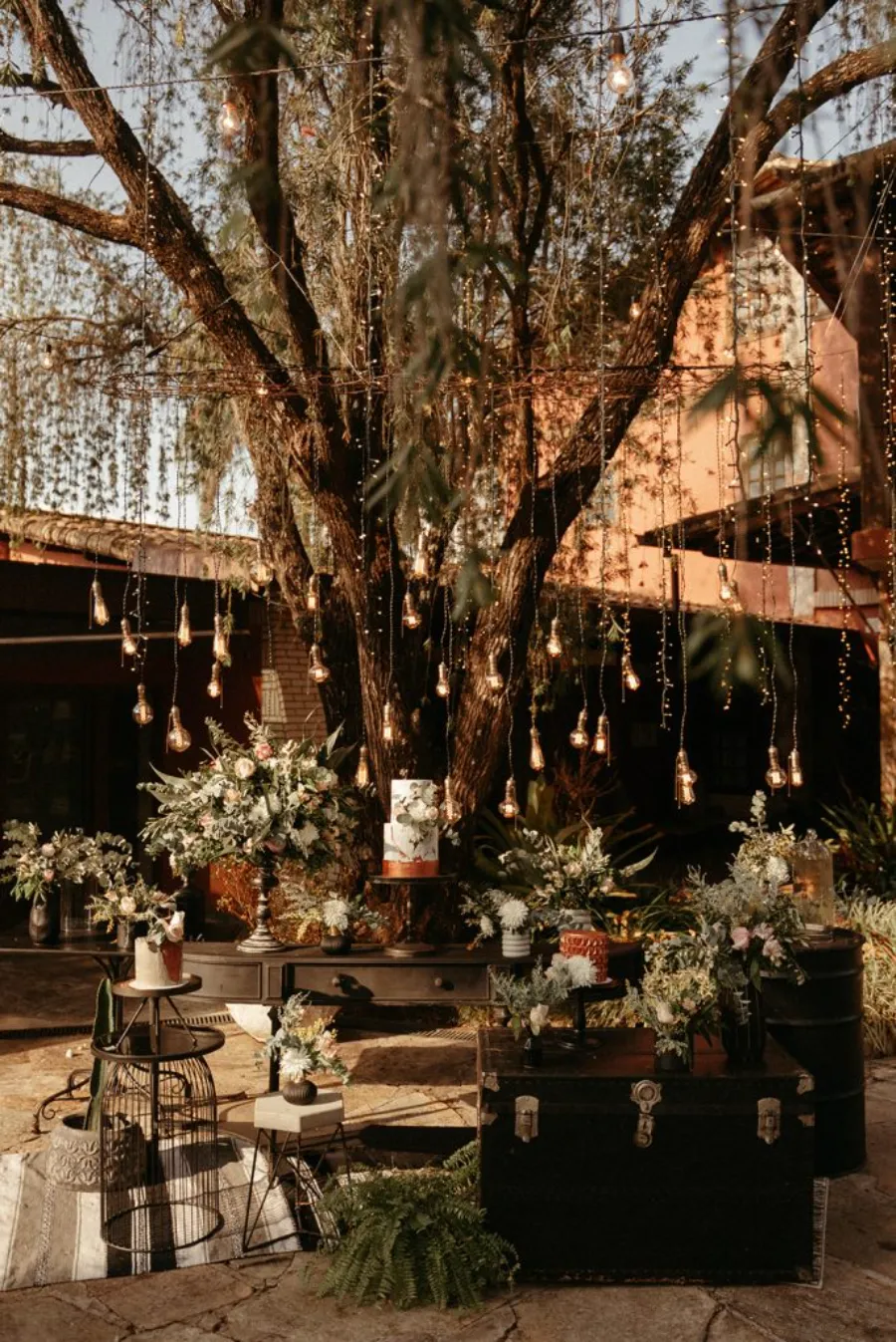 mesa do bolo de casmaneot debaixo de arvore no estilo industrial