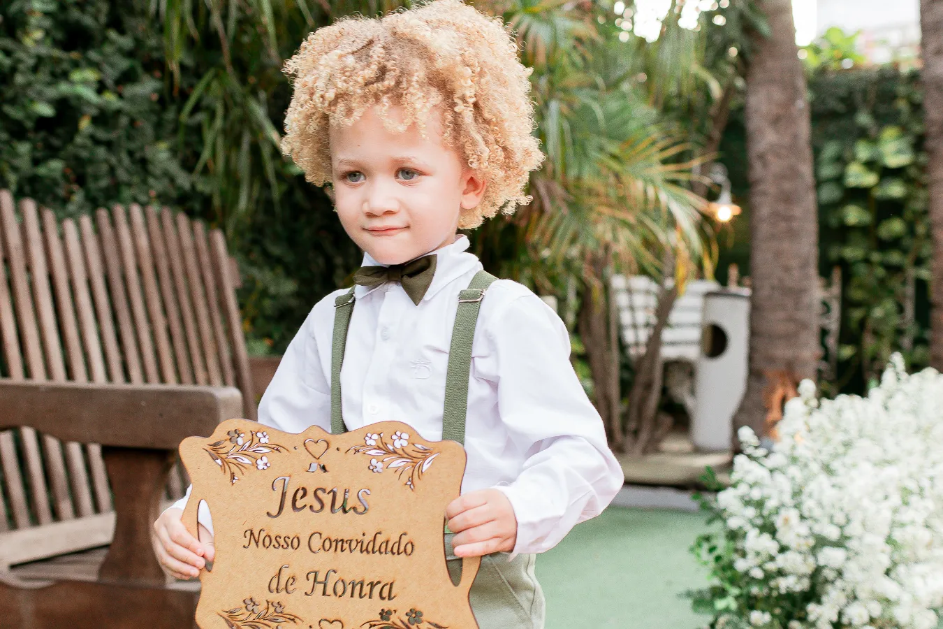 pajem carregando plaquinha de casamento