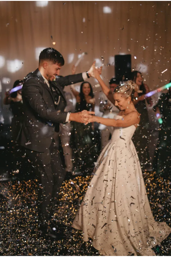 noivos dan&ccedil;ando em meio ao confeti