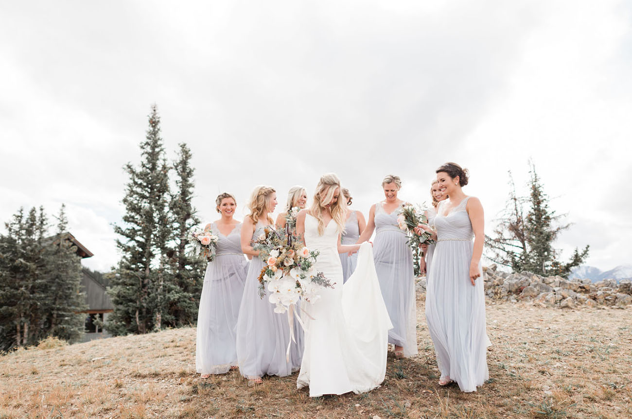 noiva ao lado das madrinhas de vestido azul claro na montanha
