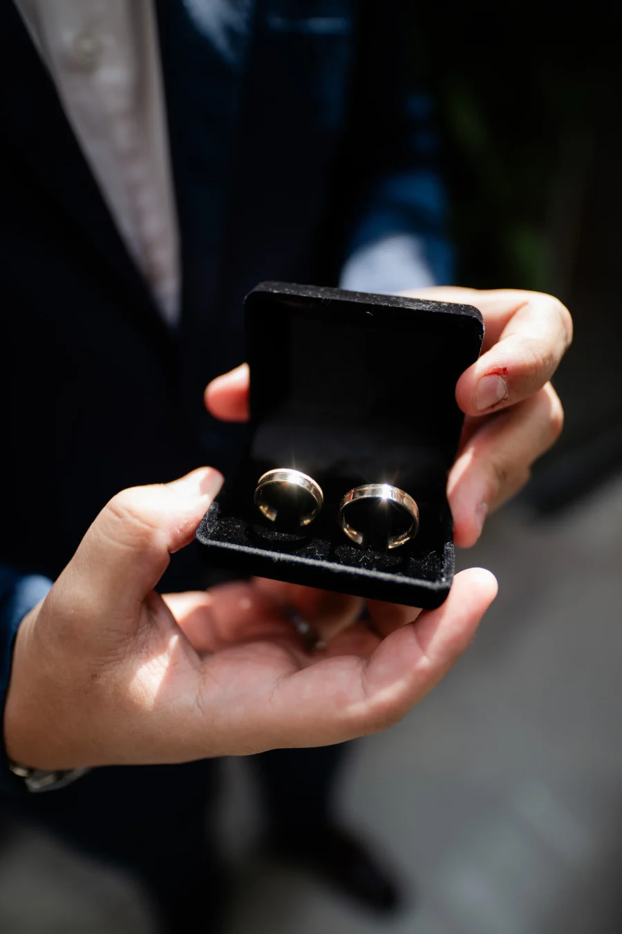 noivo mostrando caixa com alian&ccedil;as de casamento