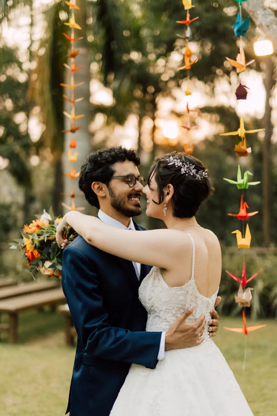 noivos abra&ccedil;ados ao lado do varal com tsurus