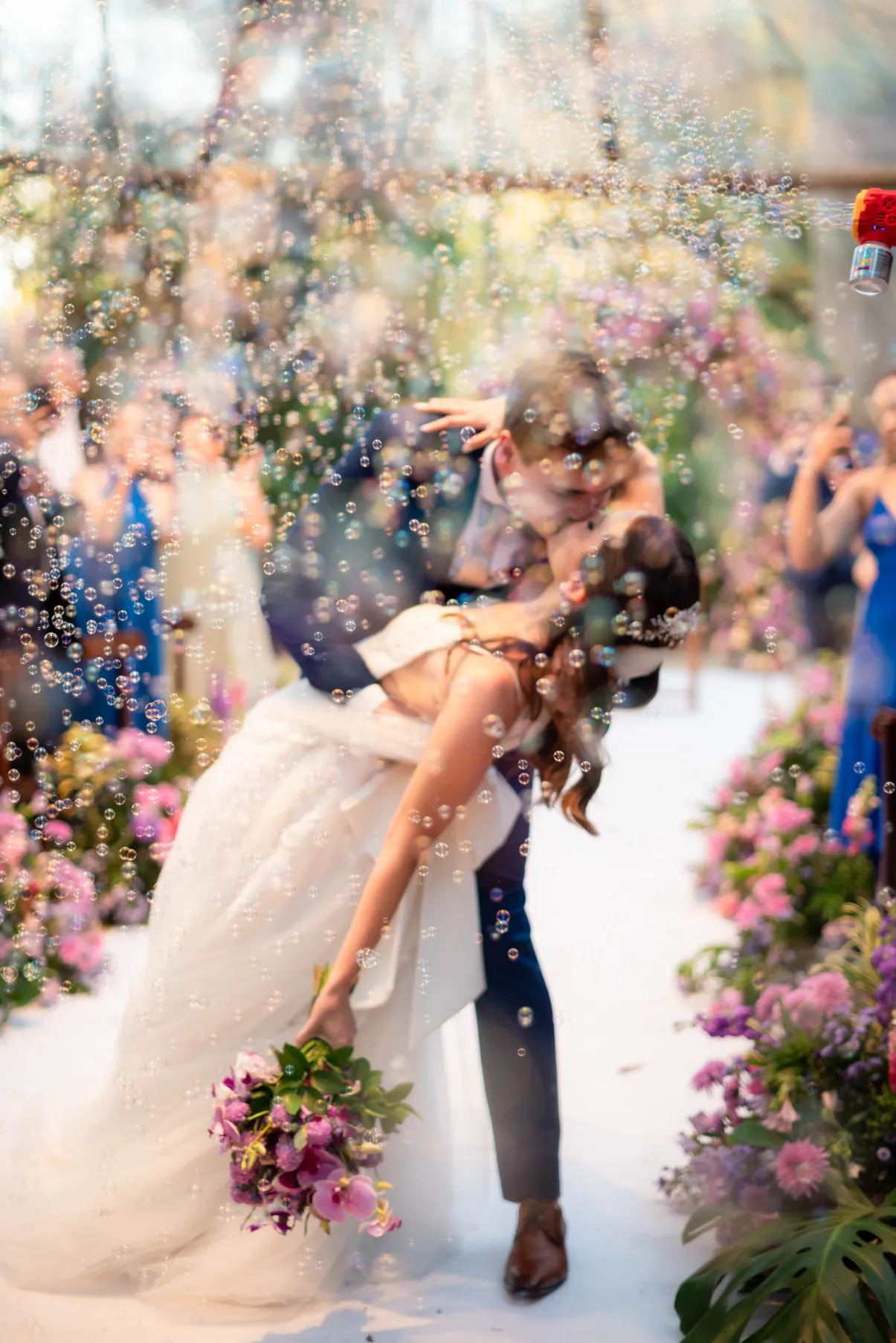 noivos se beijando na saida com bolhas de sab&atilde;o