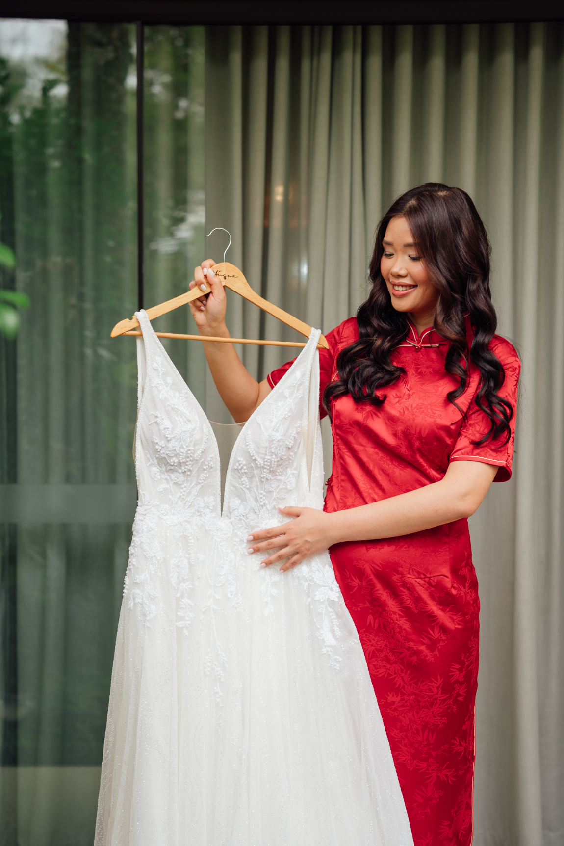 noiva com vestido vermelho ao lado do vestido de noiva