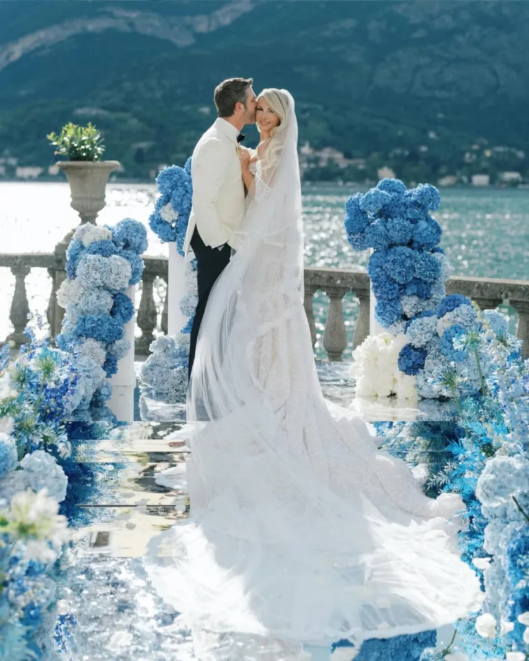 noivos em arco com flores azuis e vista para o mar