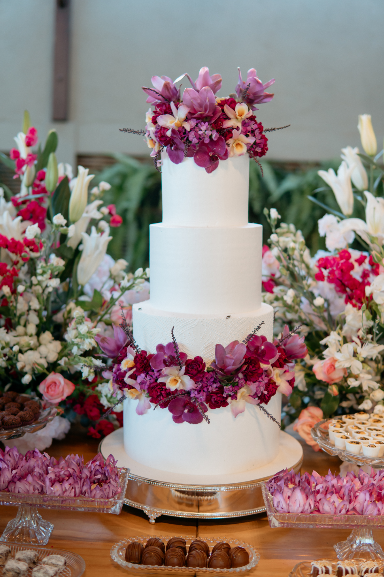 bolo de casamento branco com flores rosas e roxas