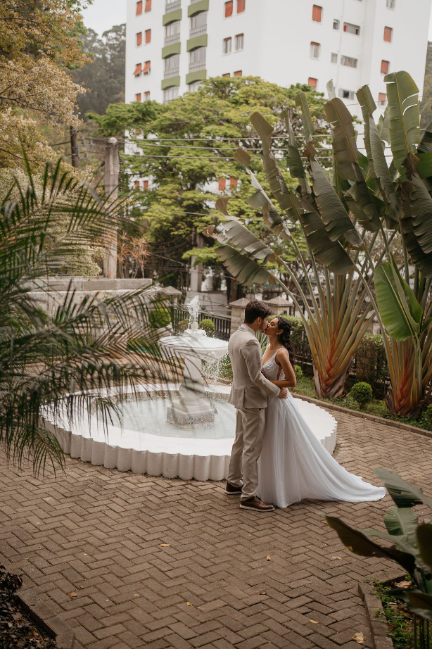 noivos se beijando na frente de fonte