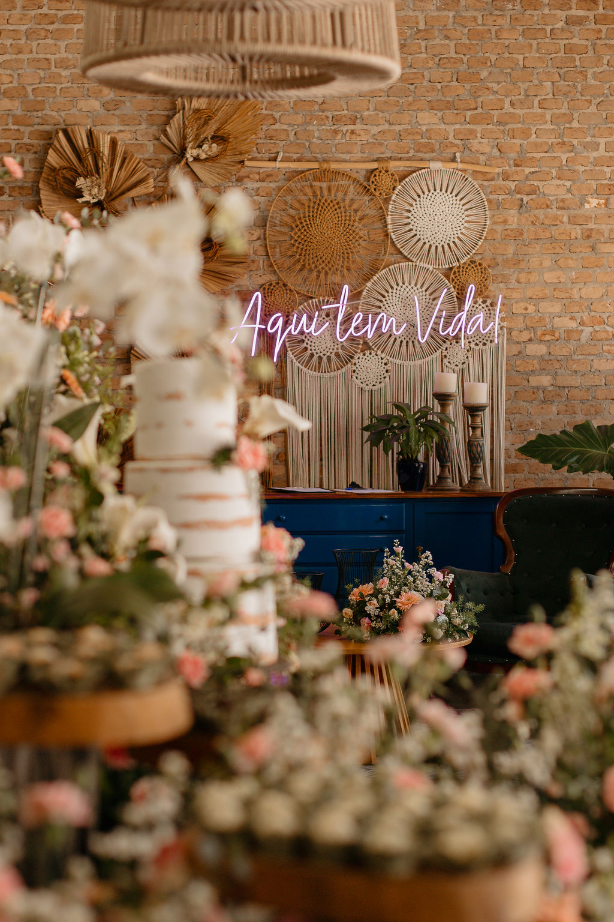mesa com bolo de casamento e paineld e led ao fundo