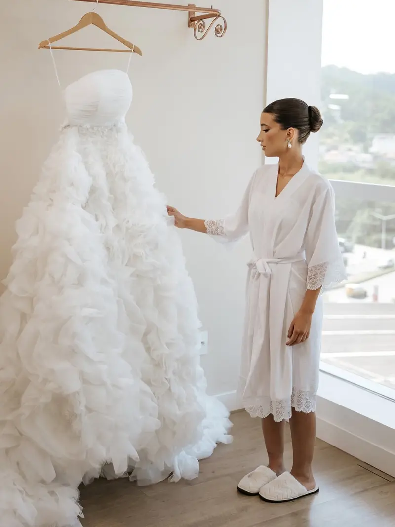 noiva com robe personalizaod olhando o vestido de noiva