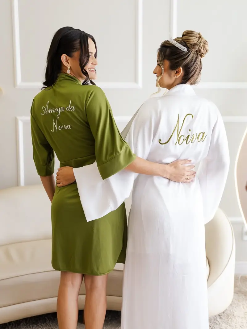 noiva com robe personalizado escrito noiva ao lado da amiga da noiva com robe verde
