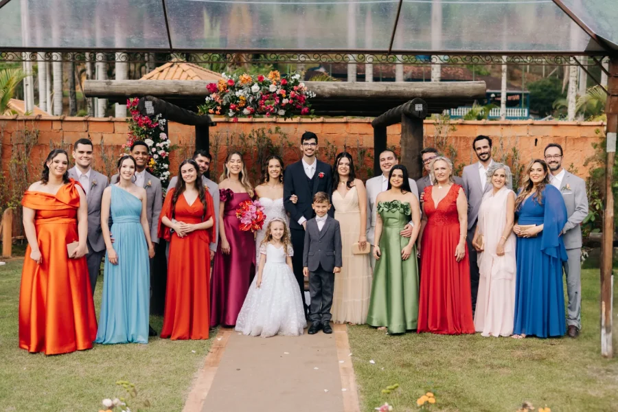 noivos ao lado de madrinhas de vestidos coloridos