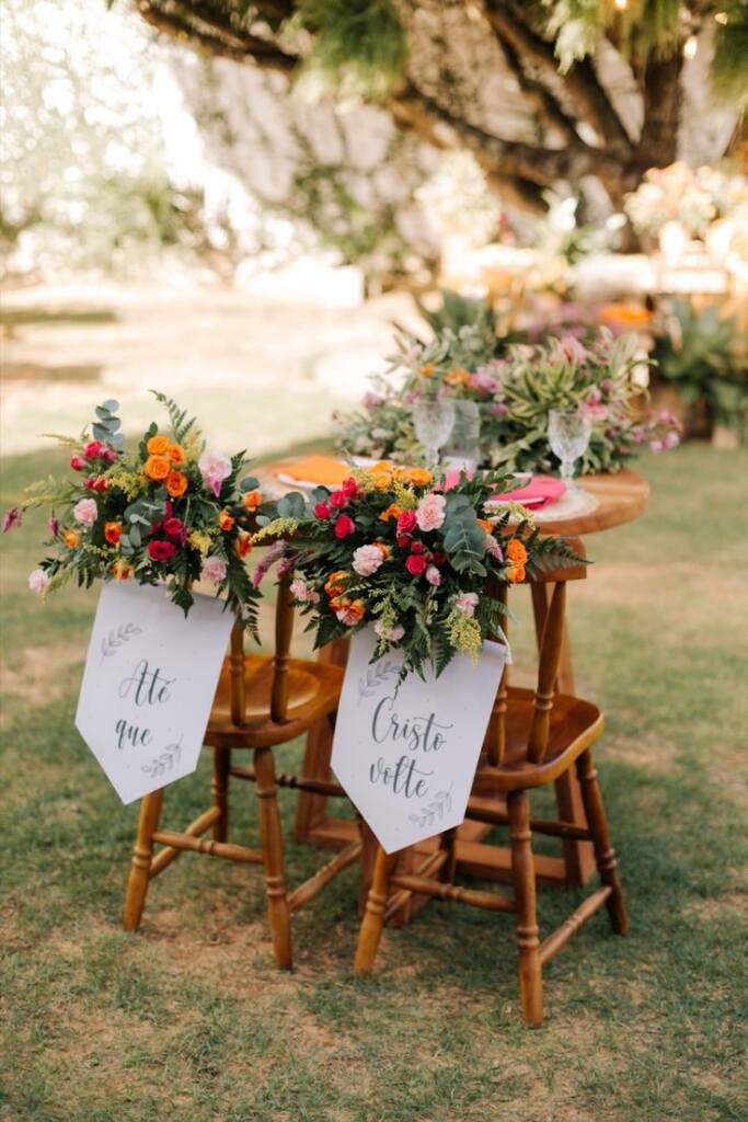 mesa com cadeiras decoradas com flores