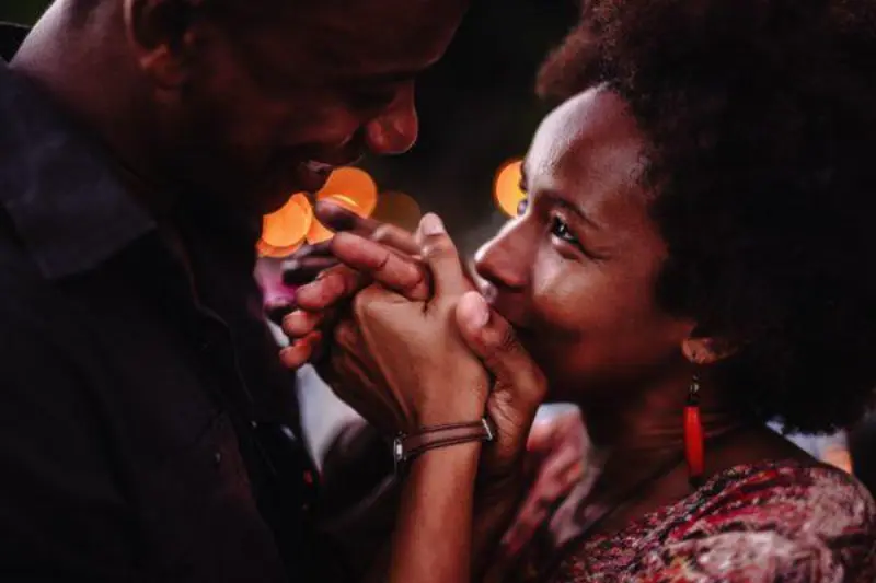 casal feliz um beijando a mão do outro