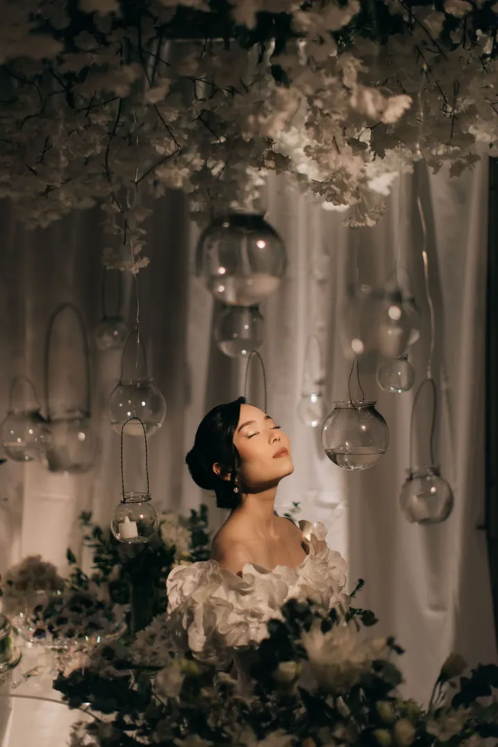 noiva com vestido maximalista perto de pendentes de vidro