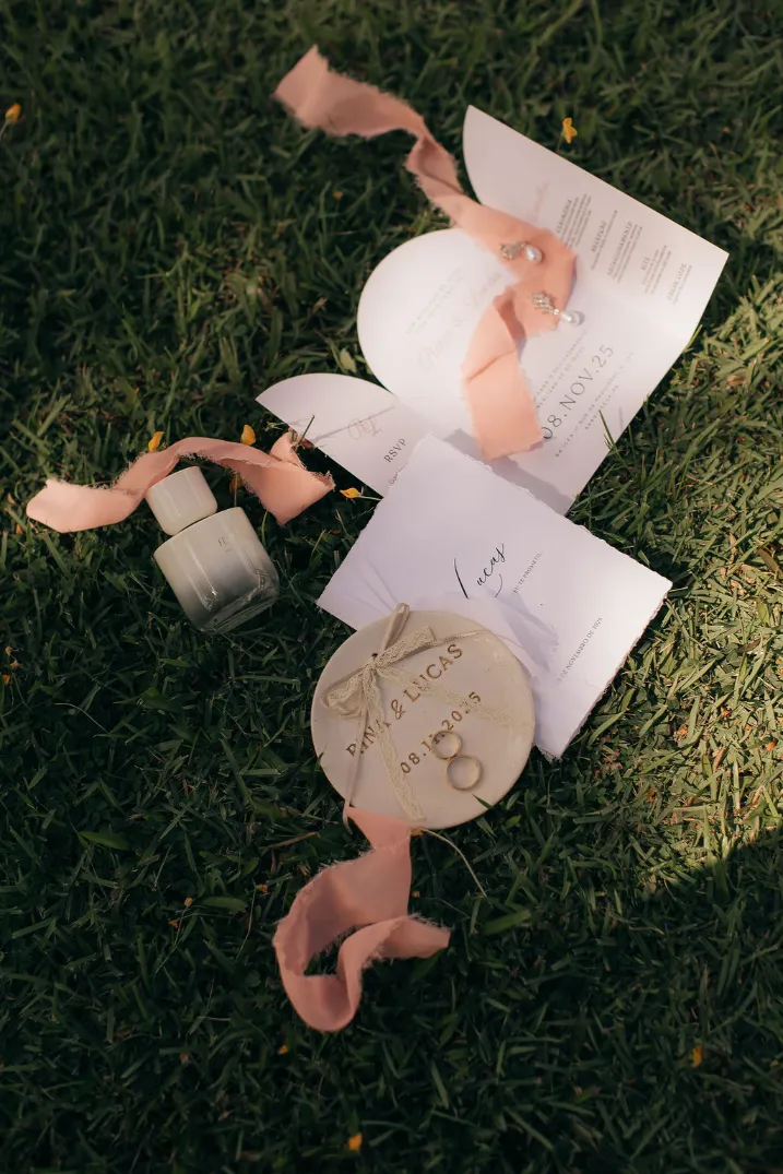 convite de casamento ao lado de porta alianças e perfume