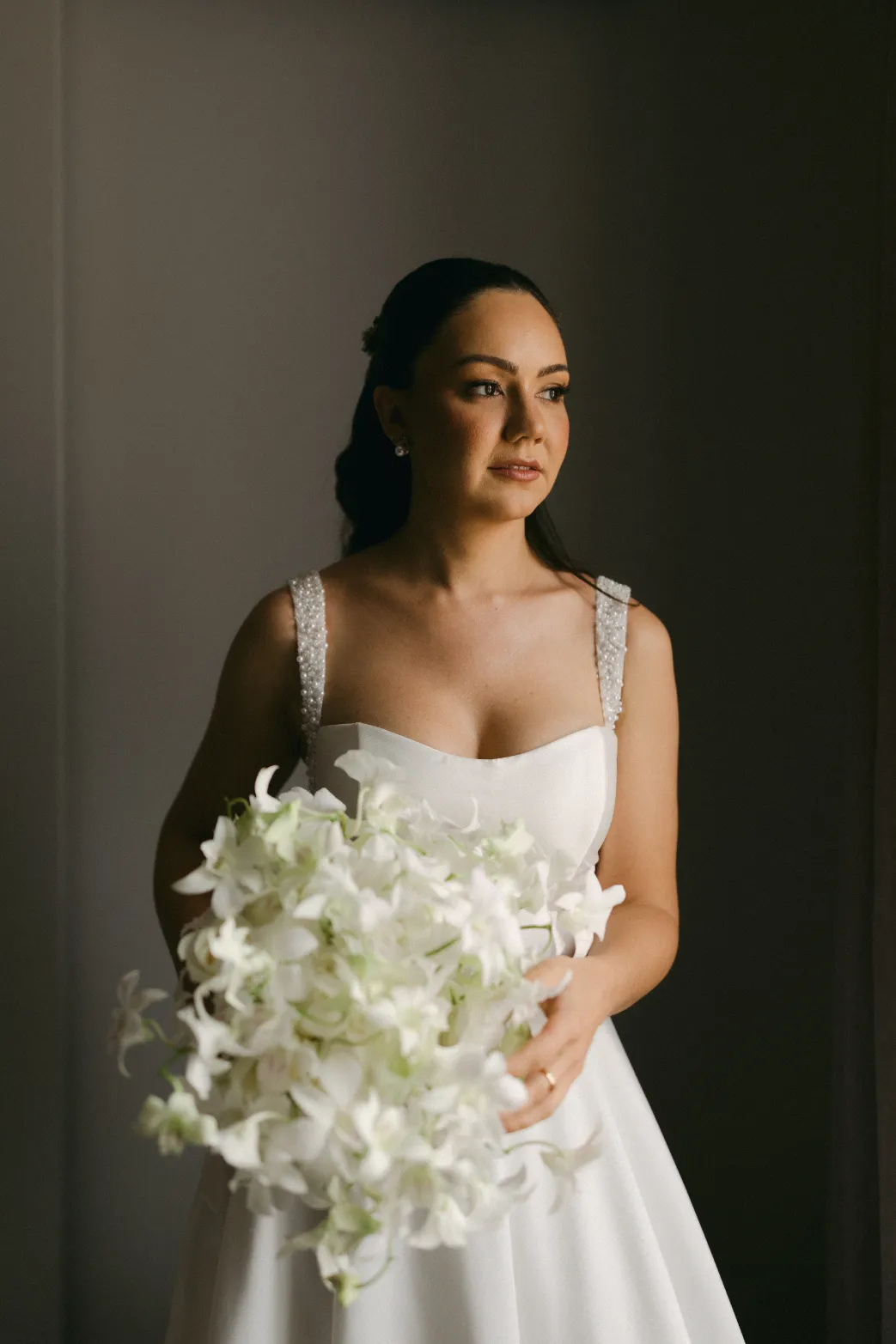 mulher com vestido de noiva segurando buque