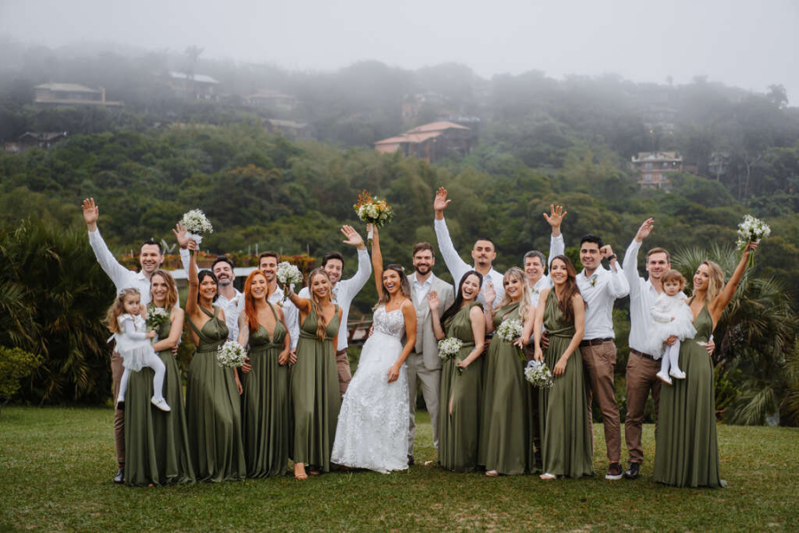noivos ao lado de madrinhas e padrinhos de verde