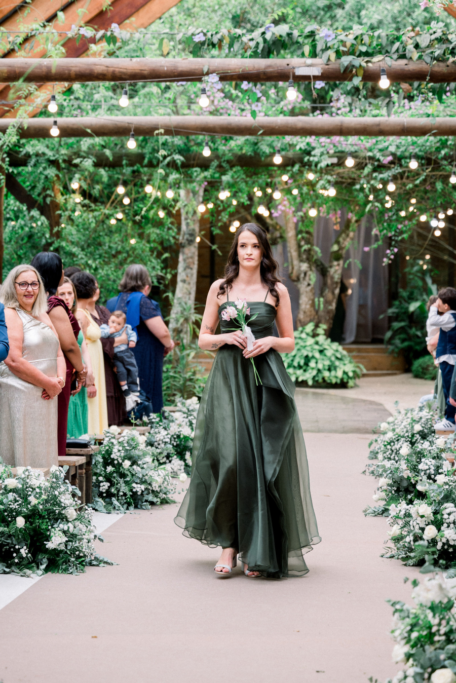 madrinha com vestido verde carregando mini buque de flores