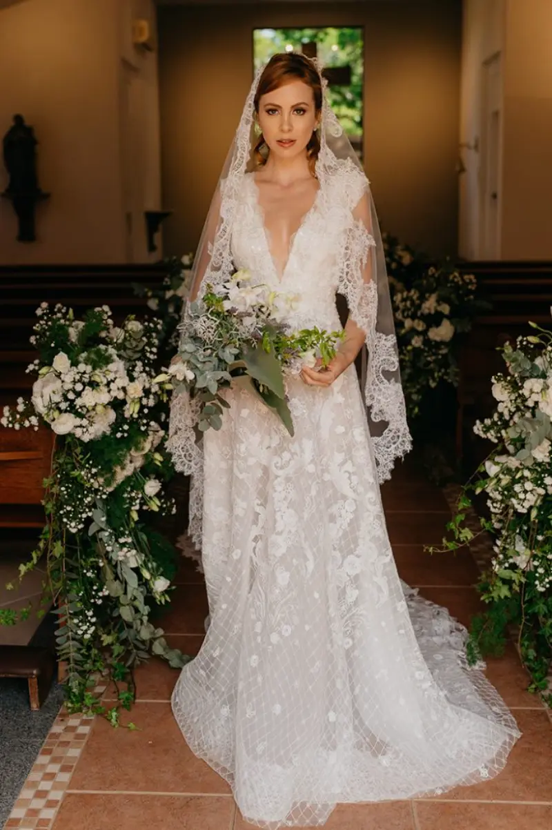 noiva no corredor da capela com vestido rendado com decote