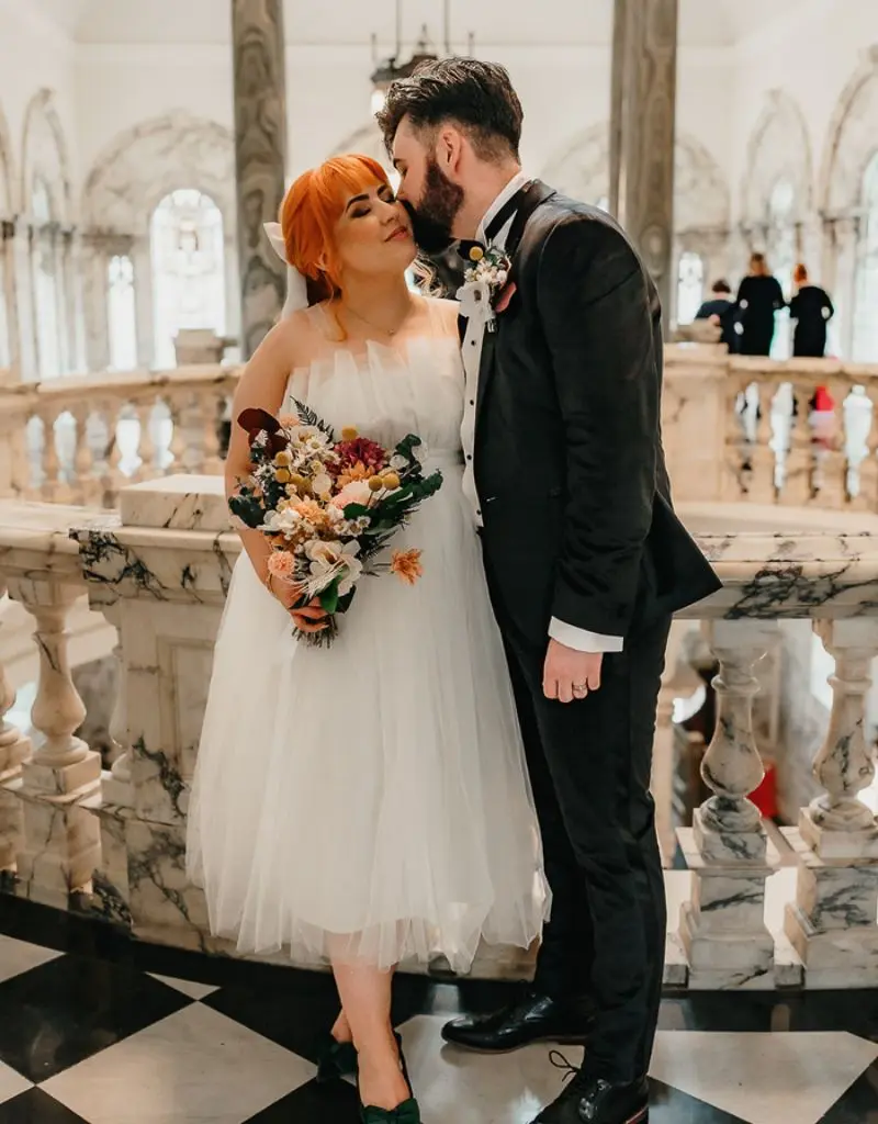noivo beijando o rosto da noiva em casamento civil