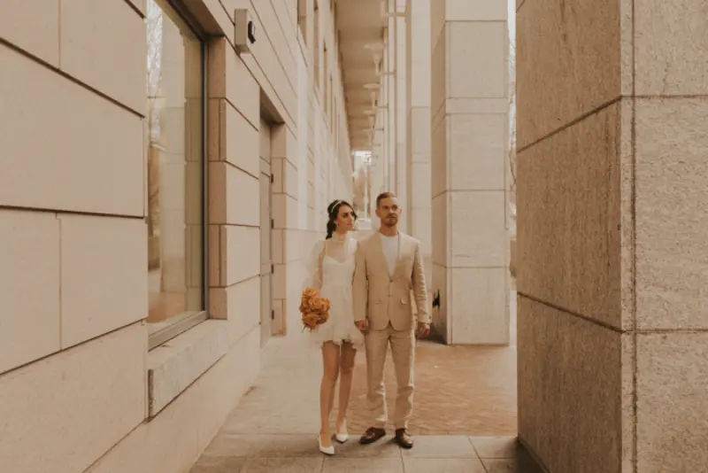 noivos de m&atilde;os dadas posando para foto depois do casamento civil