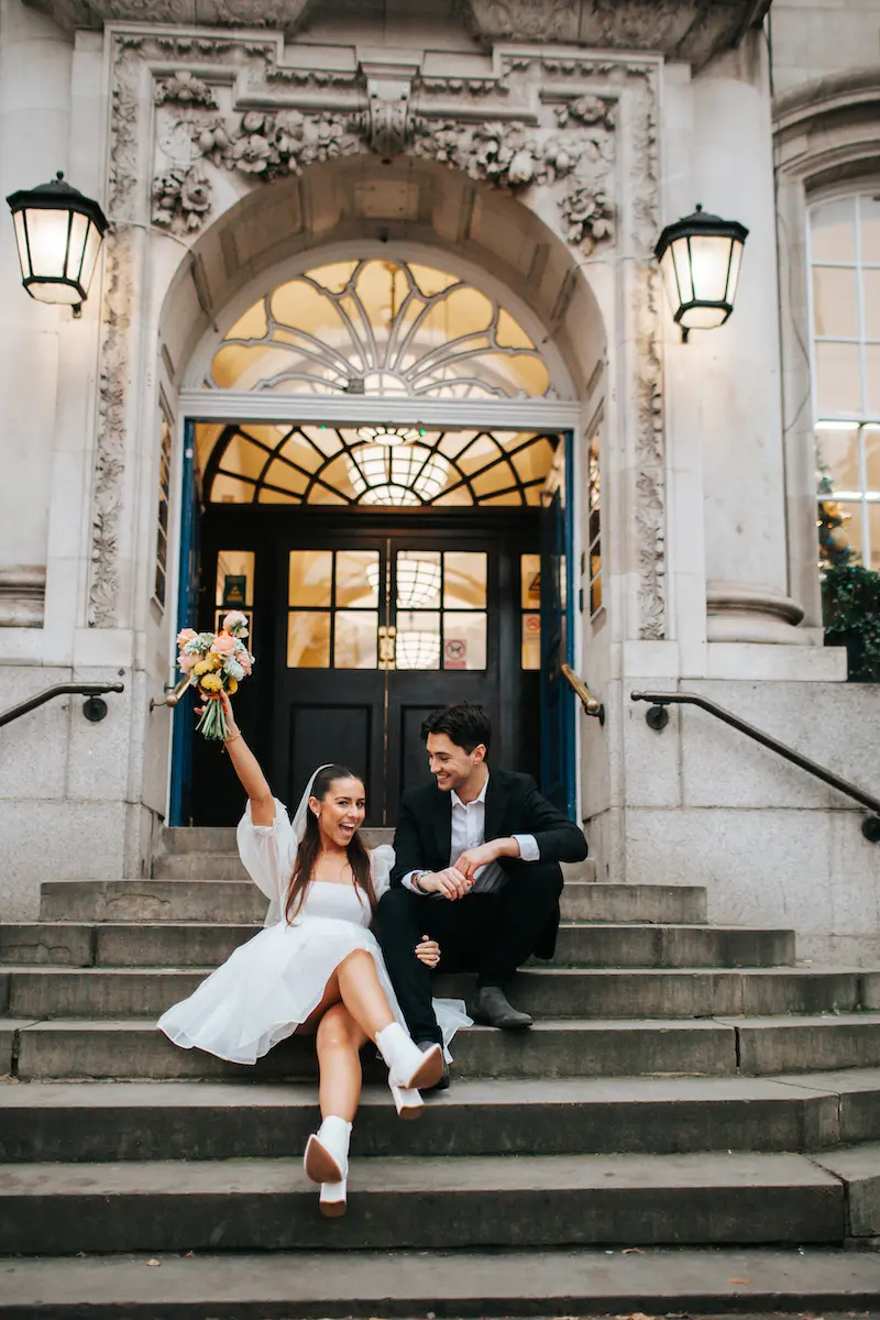 noivos sentados na escada do cart&oacute;rio