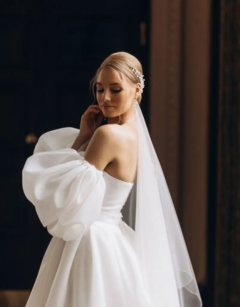 vestido de noiva apresenta um corpete justo e mangas bufantes volumosas