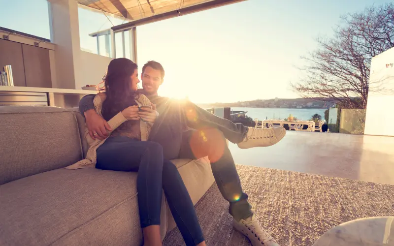 casal sentado no sofá ao por do sol em viagem de bodas de lã