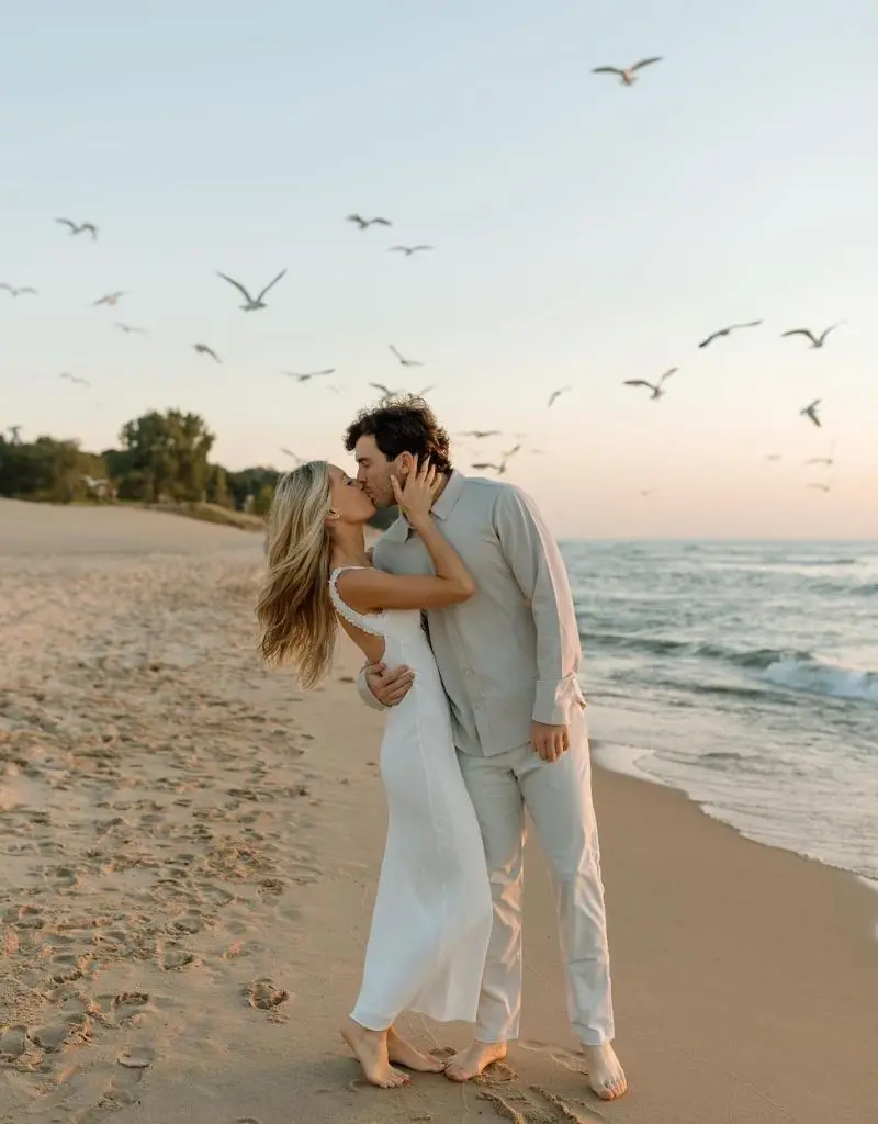 casal está vestindo roupas claras e casuais, adequadas para um ensaio na praia