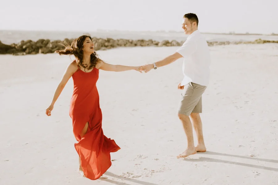 casal de mãos dadas na praia felizes em ensaio pré wedding
