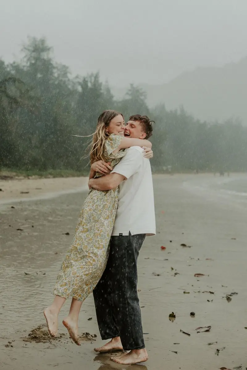 casal apaixonado sob a chuva em ensaio pré wedding na praia