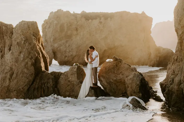 noivos se beijando em pré wedding na praia