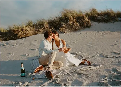 noivos sentados na areia para ensaio pré- wedding