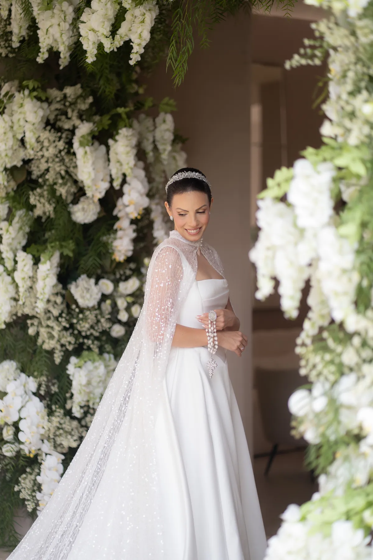 mulher com vestido de noiva com capa segurando ter&ccedil;o