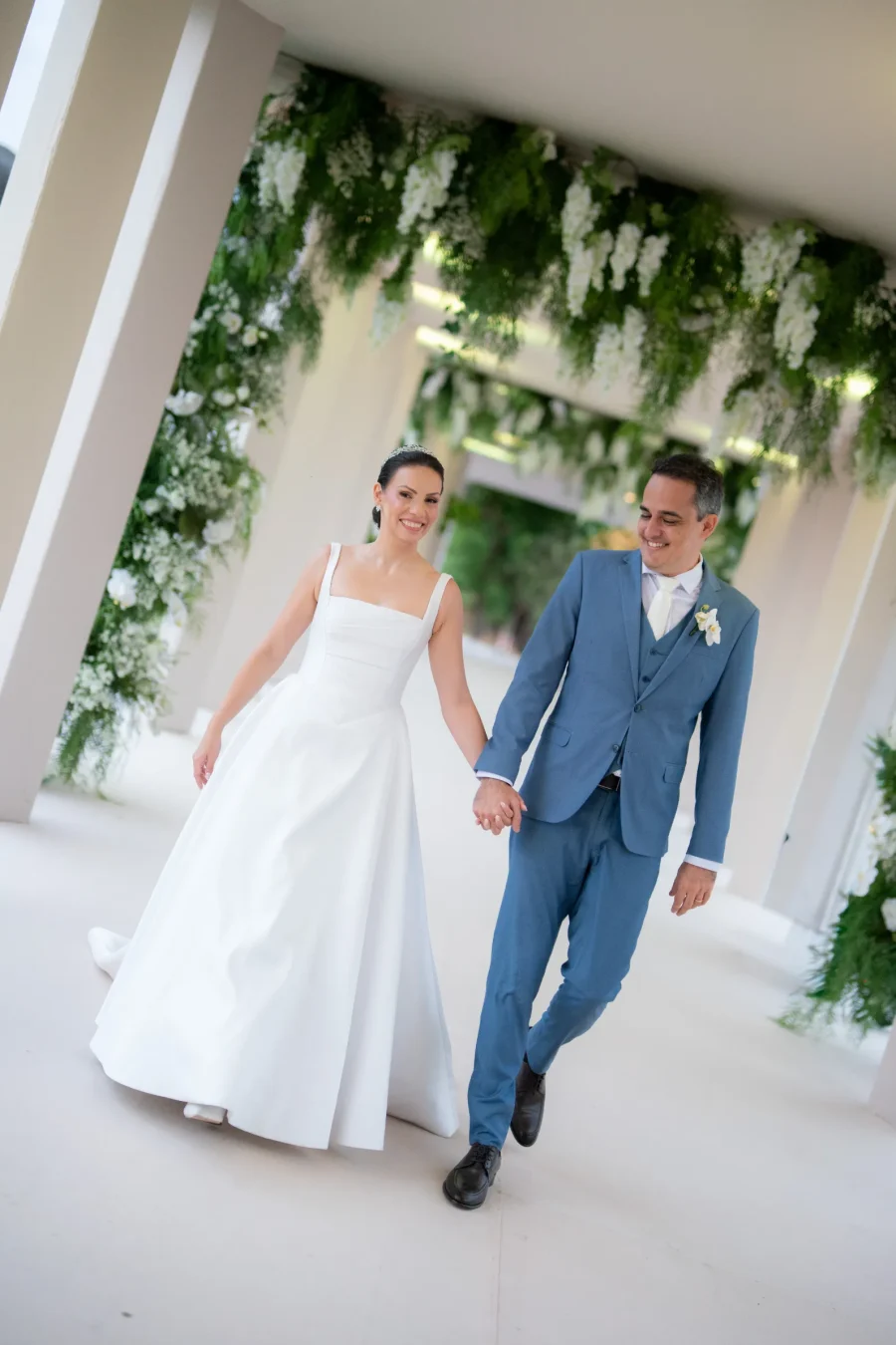 mulher com vestido minimalista de noiva ao lado do noivo de terno azul