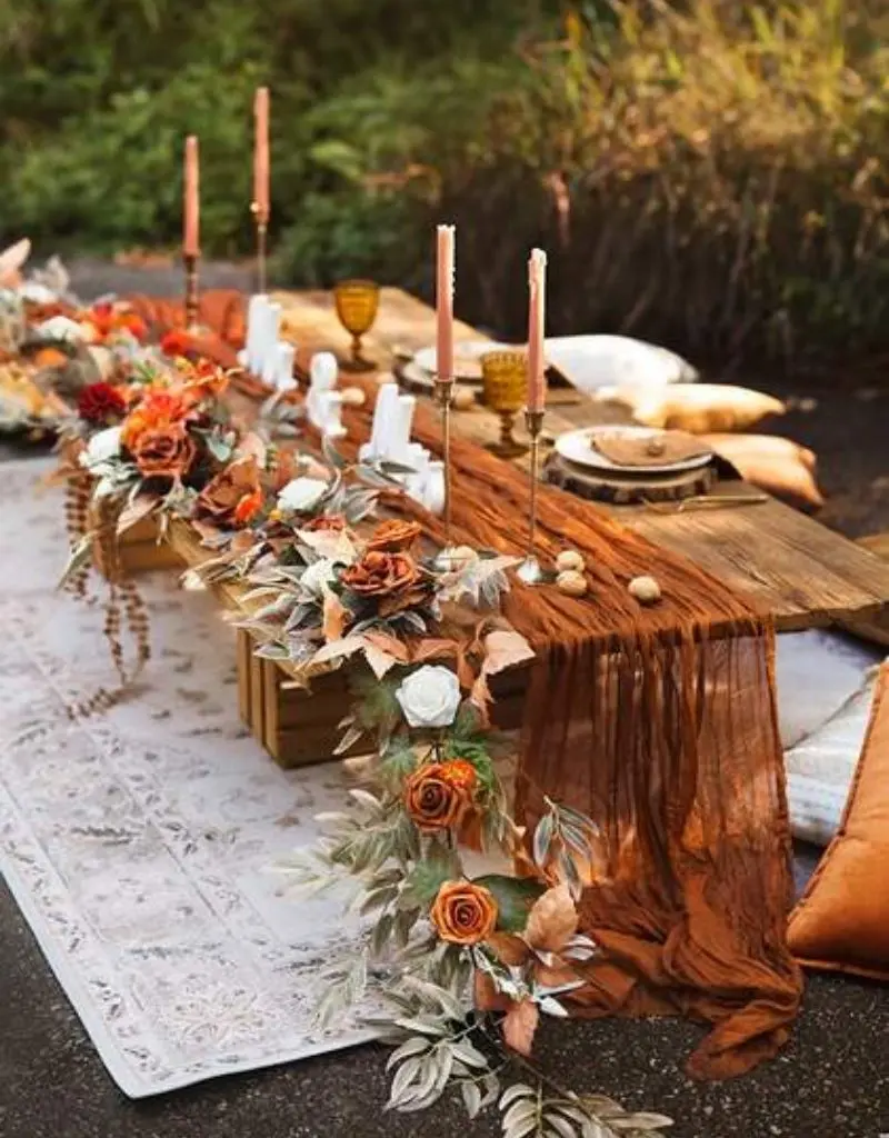 decoração de mesa de casamento em estilo rústico com caminho de mesa de gaze laranja queimado e arranjos florais de outono