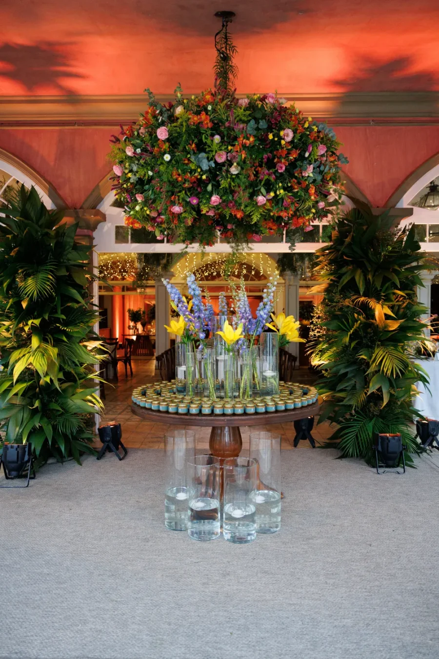 mesa com bem-casados e flores roxas e amarelas