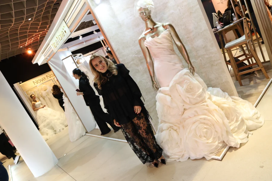 estilista ao lado do vestido de noiva