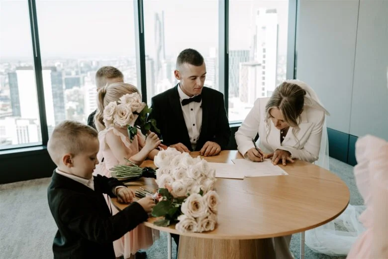 casamento civil com noiva vestindo um terno branco e está assinando os documentos.