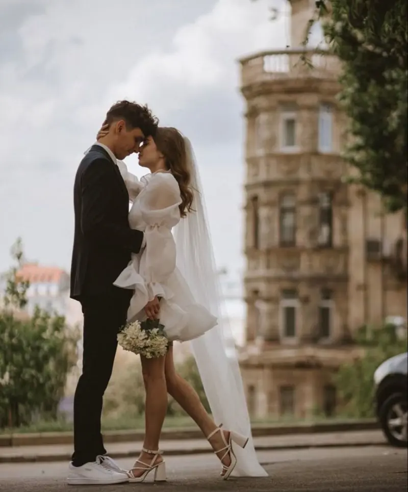 casal em um ensaio fotográfico de casamento urbano, vestindo roupas modernas e tênis branco