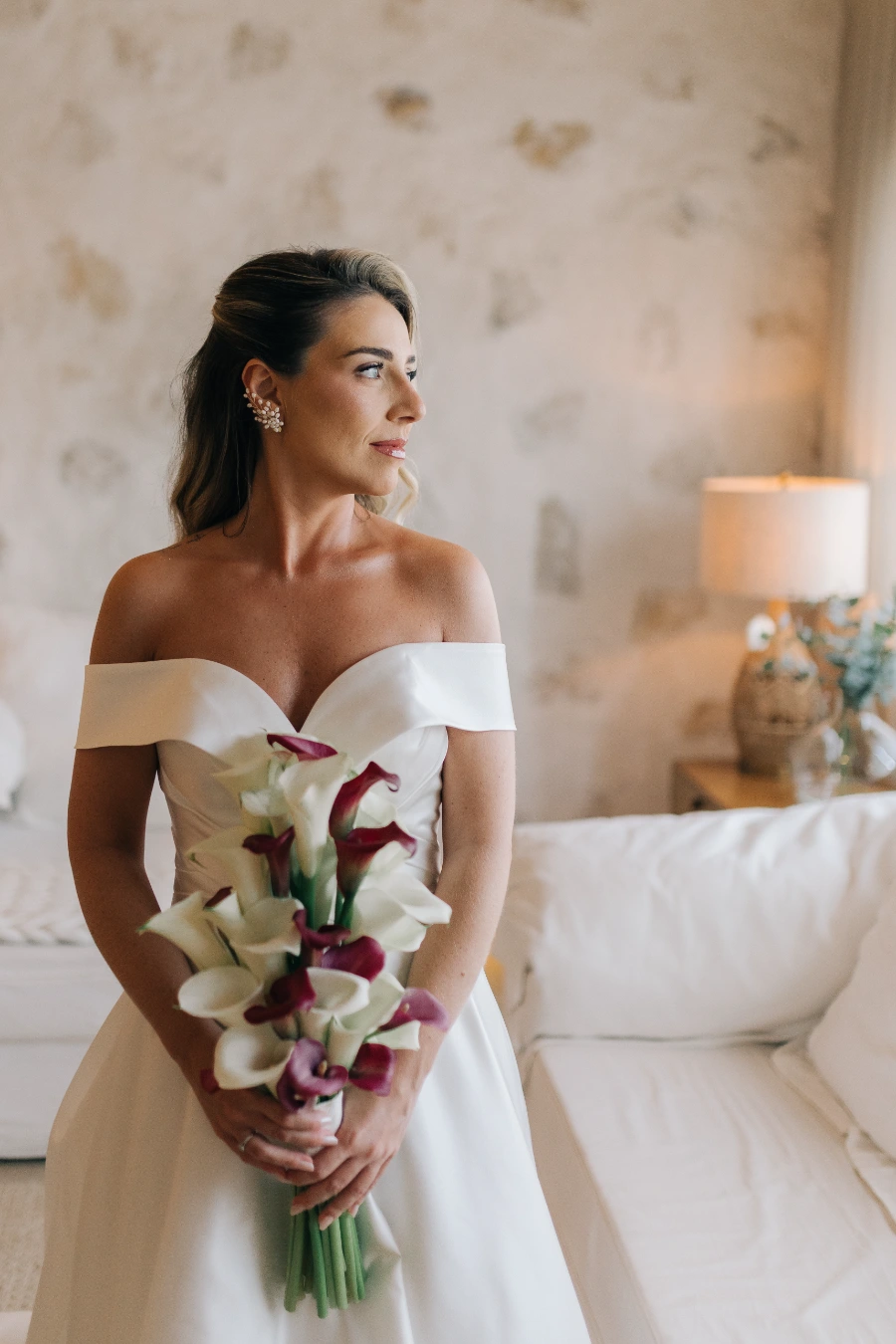 mulher com vetsido de noiva com buque vermelho e branco