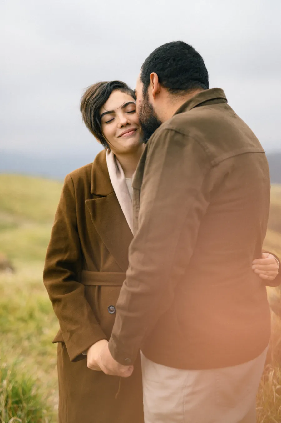 noivo beijando o rosto da noiva no pre wedding no campo